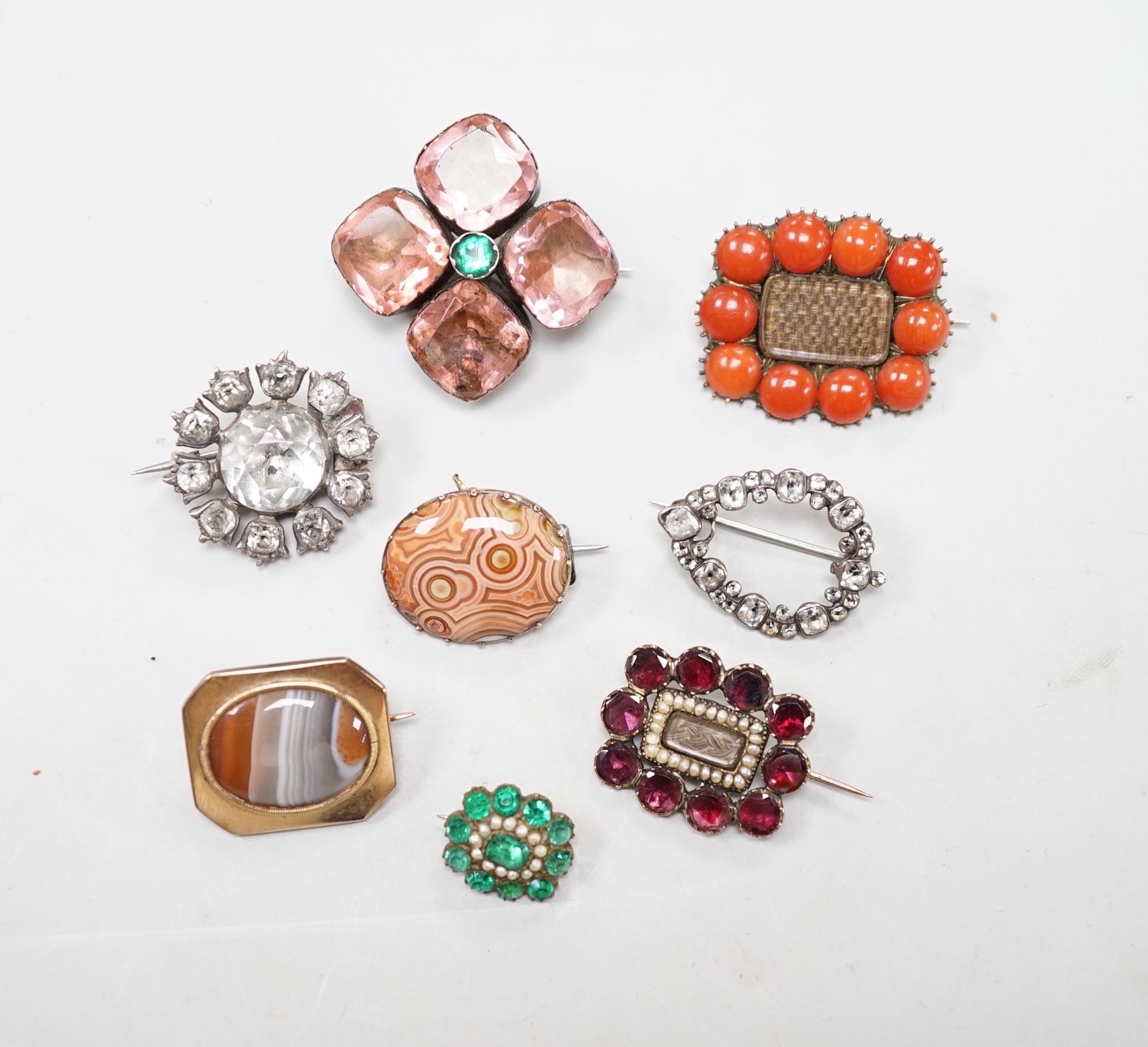 Eight assorted mainly 19th century items of jewellery, including four paste set brooches, garnet, seed pearl and plaited hair mourning brooch, a similar coral and plaited hair brooch and two chalcedony set brooches.